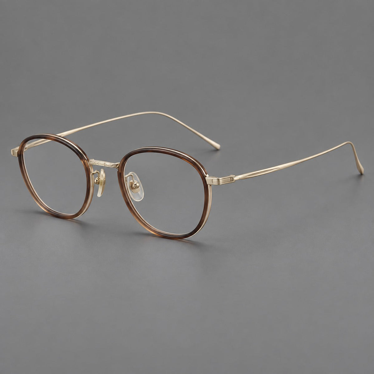 Montatura rotonda vintage in acetato e titanio con ponte inciso e aste sottili — immagine del prodotto