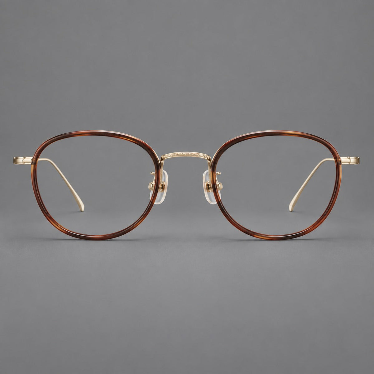Montatura rotonda vintage in acetato e titanio con ponte inciso e aste sottili — immagine del prodotto