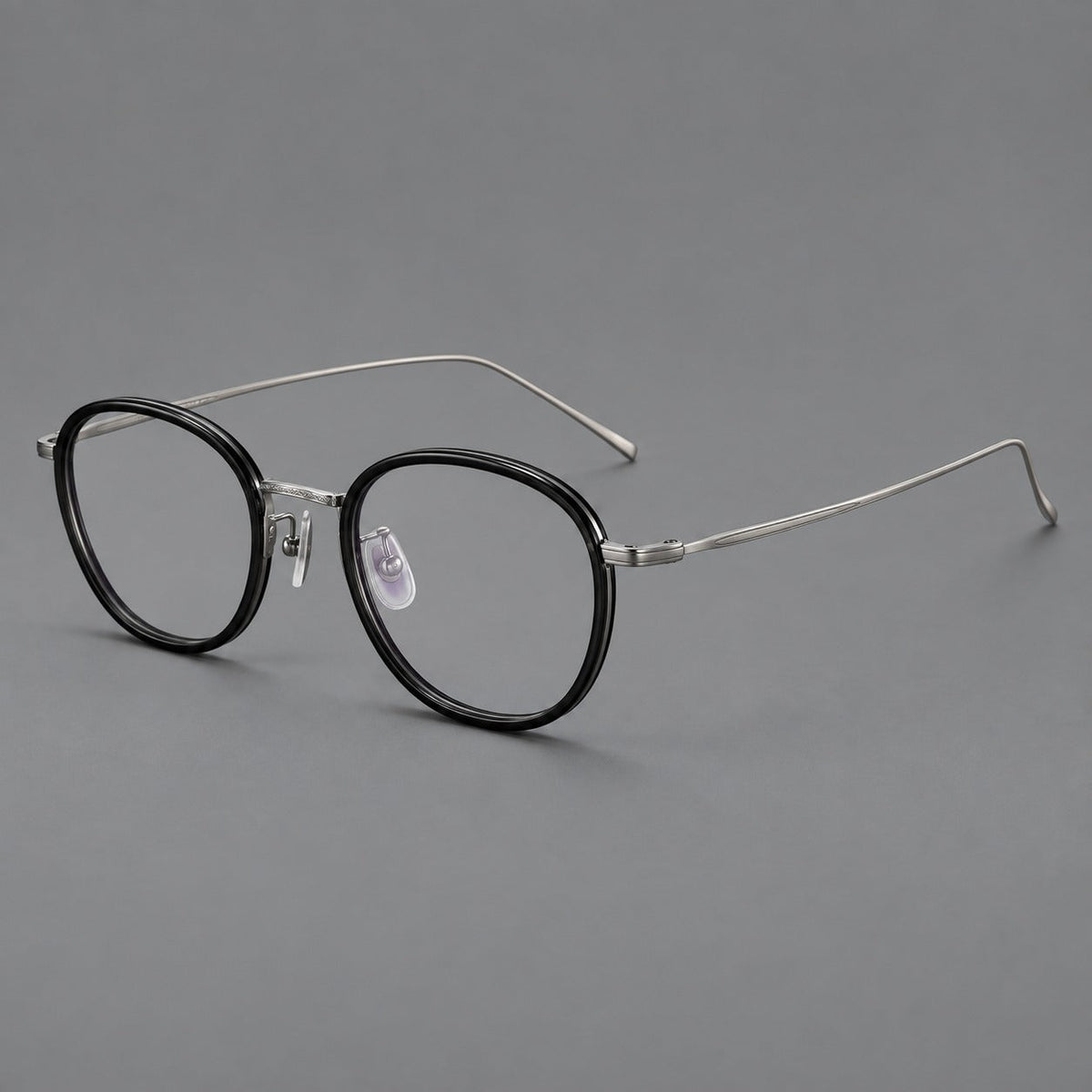 Montatura rotonda vintage in acetato e titanio con ponte inciso e aste sottili — immagine del prodotto