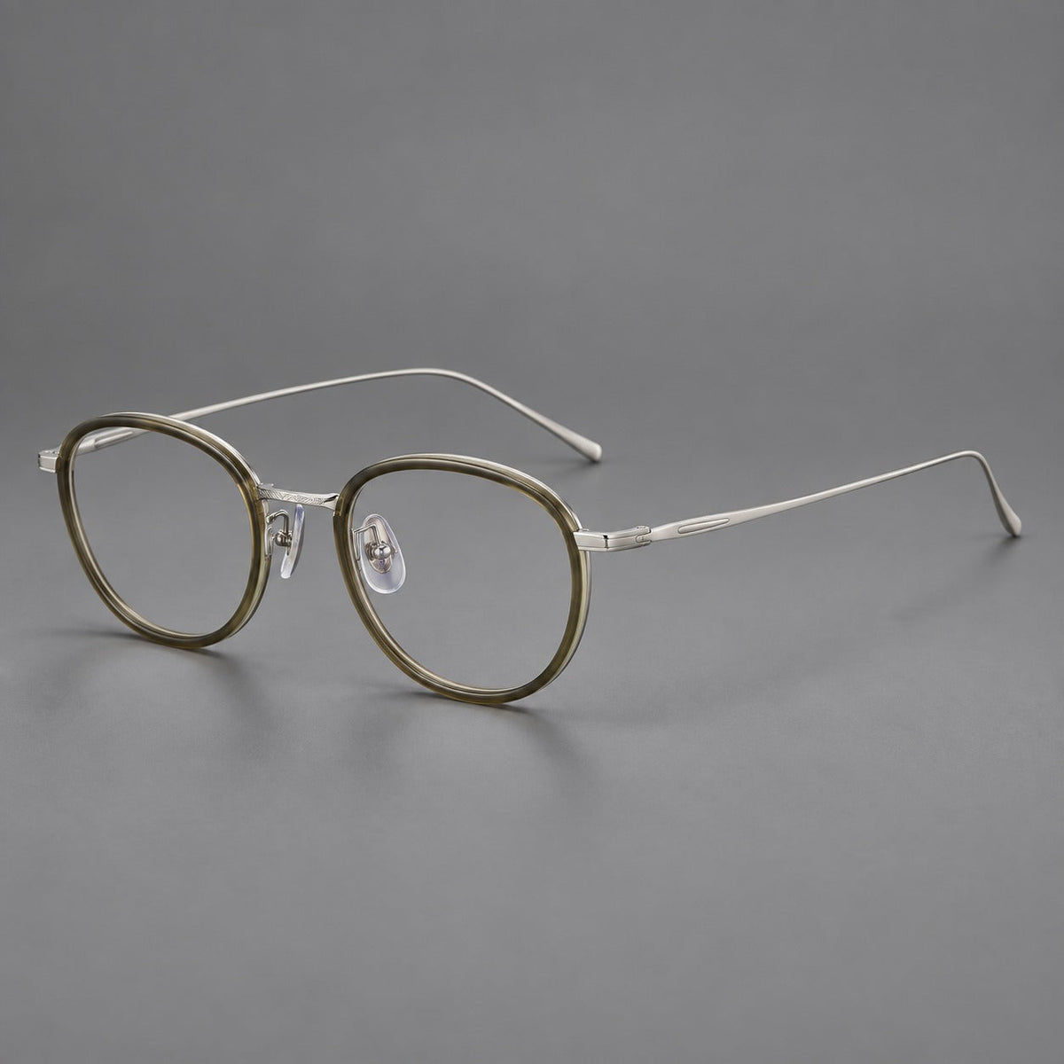 Montatura rotonda vintage in acetato e titanio con ponte inciso e aste sottili — immagine del prodotto