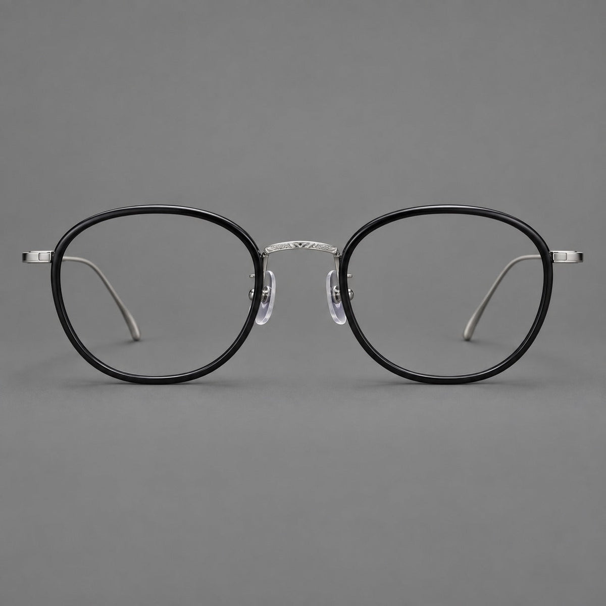 Montatura rotonda vintage in acetato e titanio con ponte inciso e aste sottili — immagine del prodotto