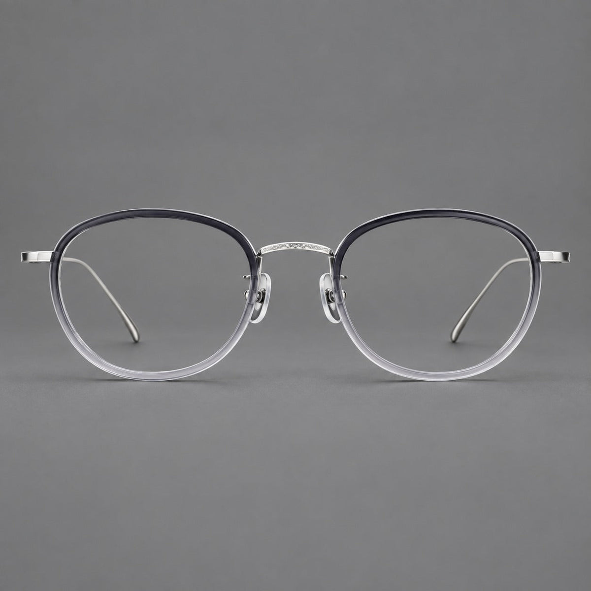 Montatura rotonda vintage in acetato e titanio con ponte inciso e aste sottili — immagine del prodotto